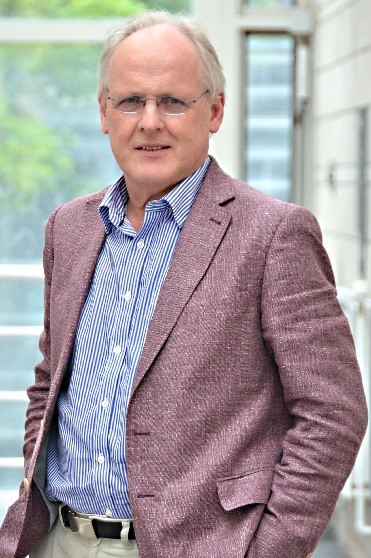 Steve Furber - Wearing purple jacket and blue striped shirt, glasses and grey hair